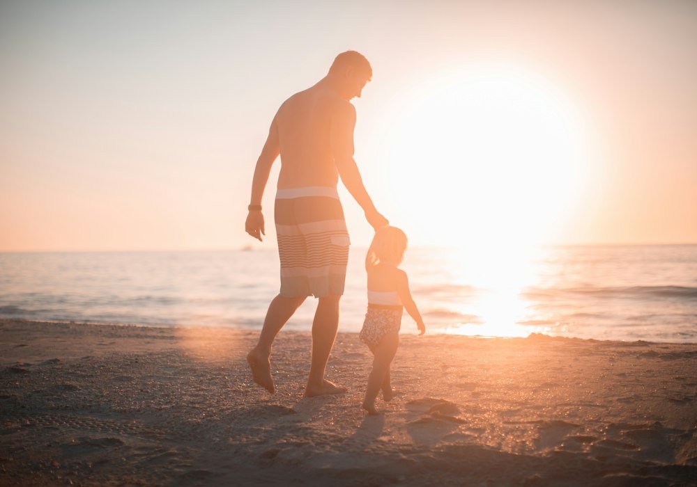 Père et enfant marchant vers la mer
